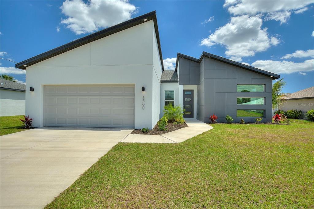 24399 Southwest Kingsway Circle Punta Gorda, FL 33983 - Photo 1 of 38 a front view of a house with a yard and garage