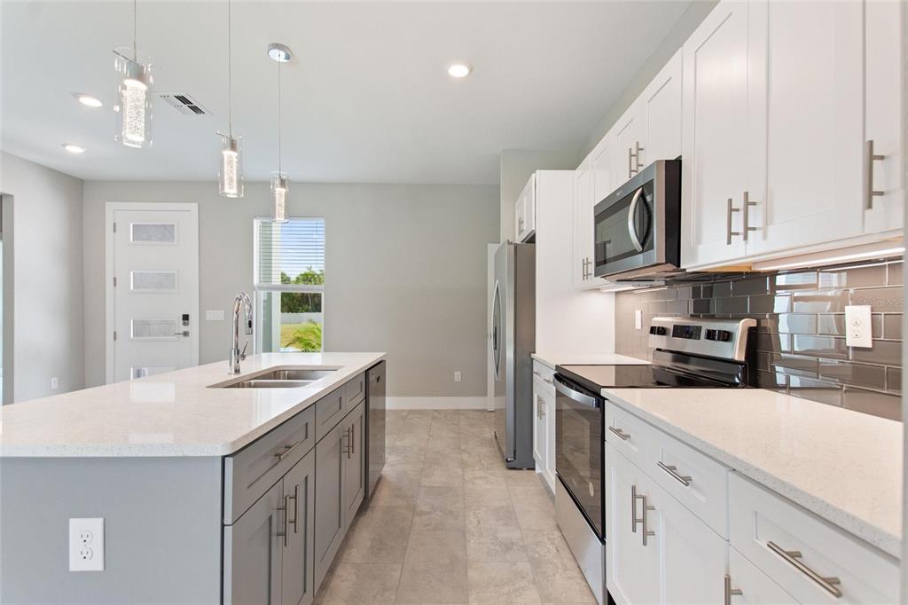 24399 Southwest Kingsway Circle Punta Gorda, FL 33983 - Photo 16 of 38 a kitchen with a sink stove and microwave