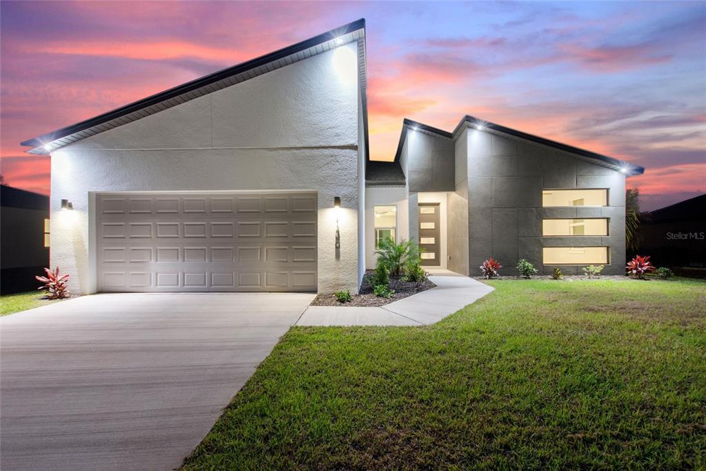 24399 Southwest Kingsway Circle Punta Gorda, FL 33983 - Photo 2 of 38 a front view of a house with a yard and garage