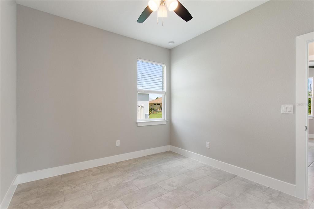 24399 Southwest Kingsway Circle Punta Gorda, FL 33983 - Photo 24 of 38 an empty room with a window and a ceiling fan