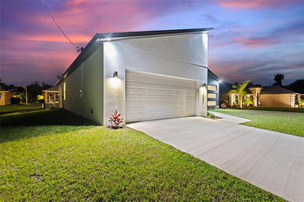 24399 Southwest Kingsway Circle Punta Gorda, FL 33983 - Photo 6 of 38 a front view of a house with a yard and garage