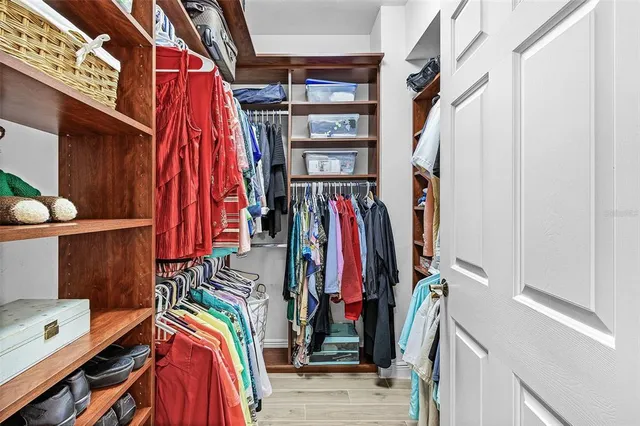a view of walk in closet with clothes and shoes