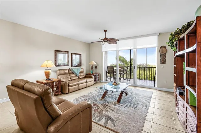a living room with furniture a flat screen tv and a large window