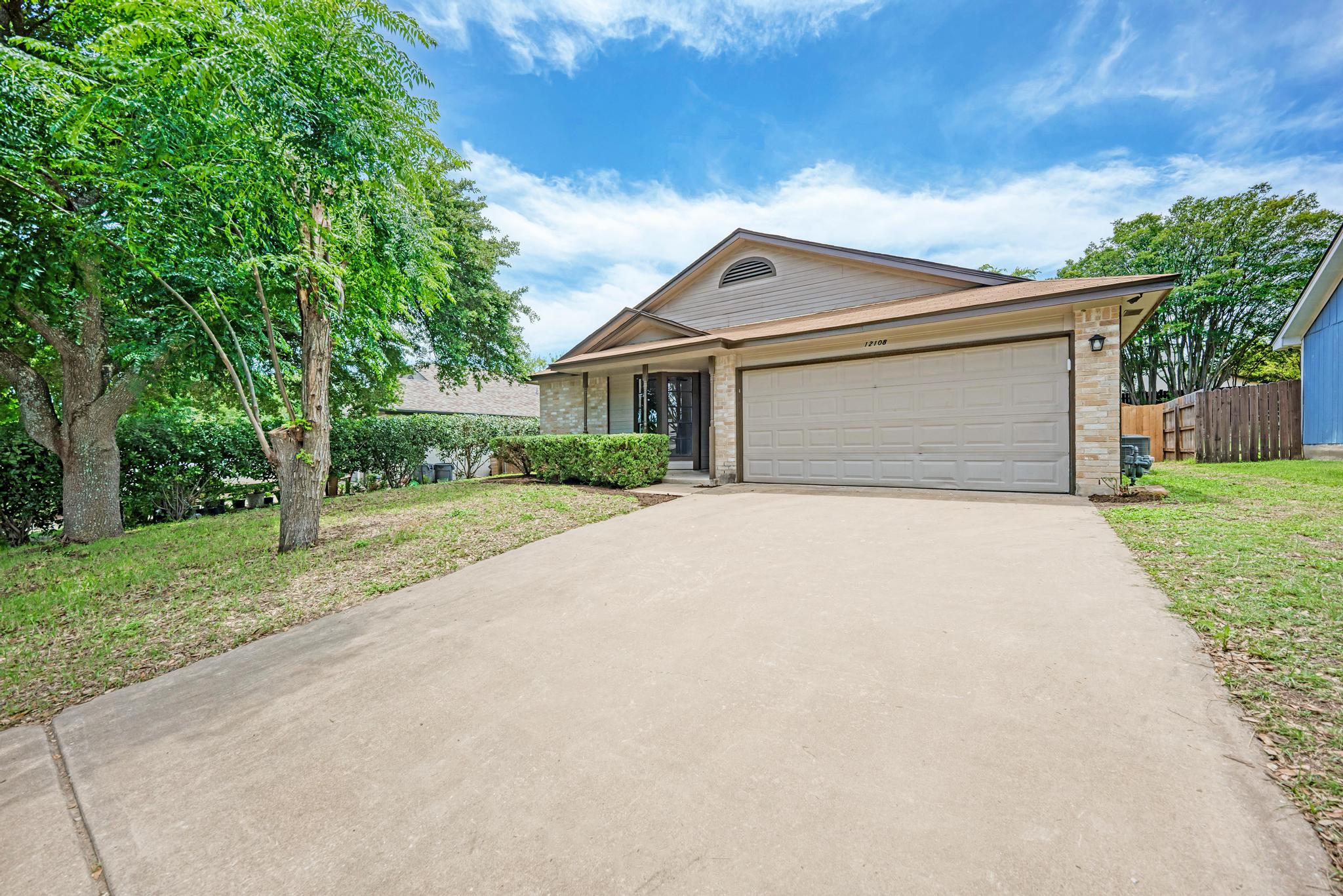 12108 Carnforth Drive Austin, TX 78753 - Photo 1 of 33 a front view of a house with a garden and trees
