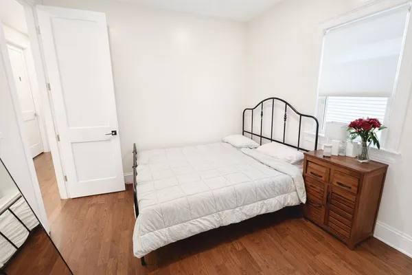 a bedroom with a bed and wooden floor