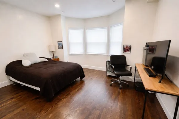 a spacious bedroom with a bed and a desk