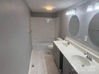 a bathroom with a double vanity sink mirror and toilet