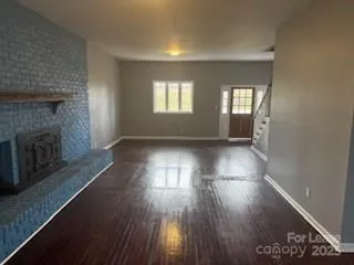 an empty room with wooden floor and fireplace