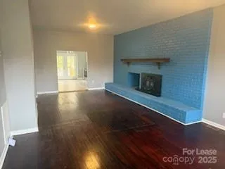 an empty room with wooden floor and fireplace