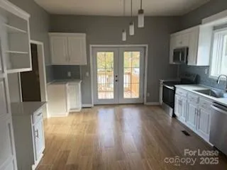 a view of a kitchen with a sink a refrigerator and cabinets