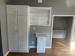 a view of an empty room with wooden floor and closet