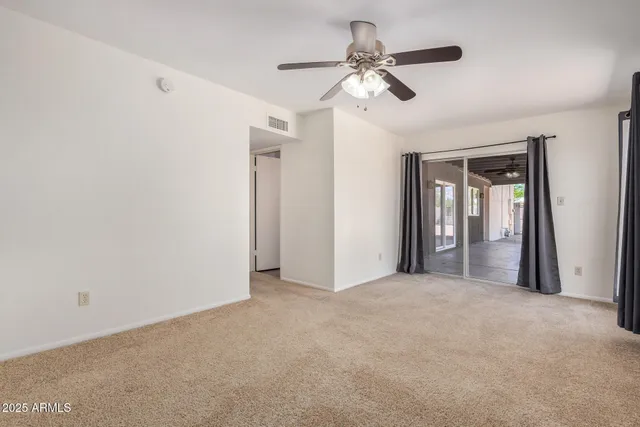 a view of a room with a ceiling fan and a window