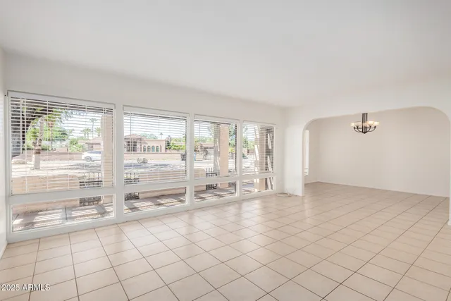 a view of a livingroom with a chandelier fan and windows