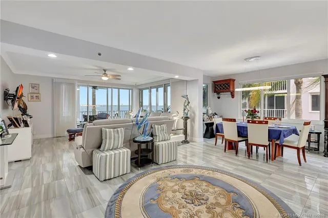 a living room with furniture a flat screen tv and a floor to ceiling window