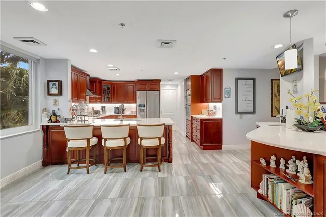a living room with stainless steel appliances a table chairs and wooden floor