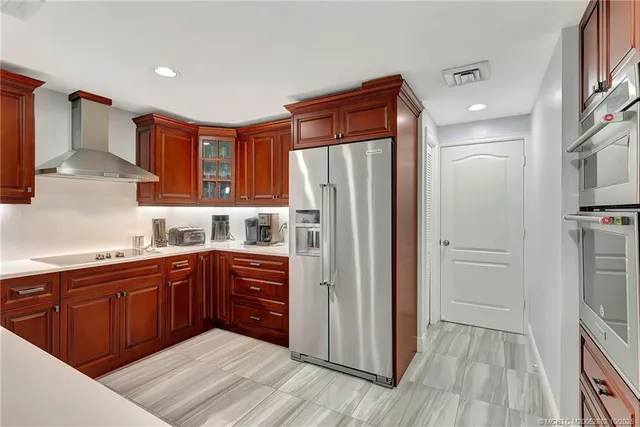 a large kitchen with stainless steel appliances granite countertop a lot of counter space and wooden floors