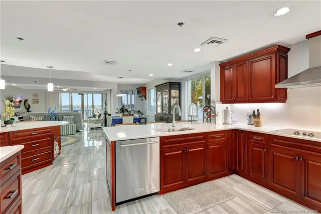 a large kitchen with stainless steel appliances granite countertop a sink and wooden cabinets