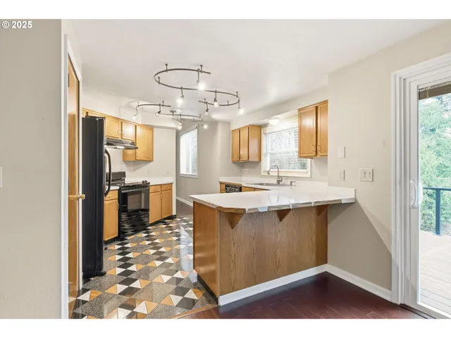a view of a kitchen with stainless steel appliances a sink and a refrigerator