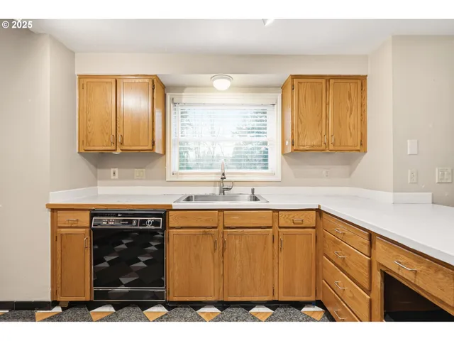 a kitchen with a sink cabinets and window
