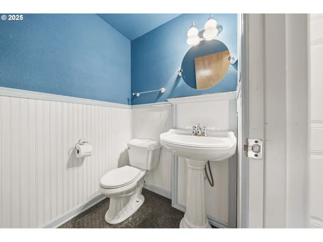 a bathroom with a toilet sink vanity and mirror