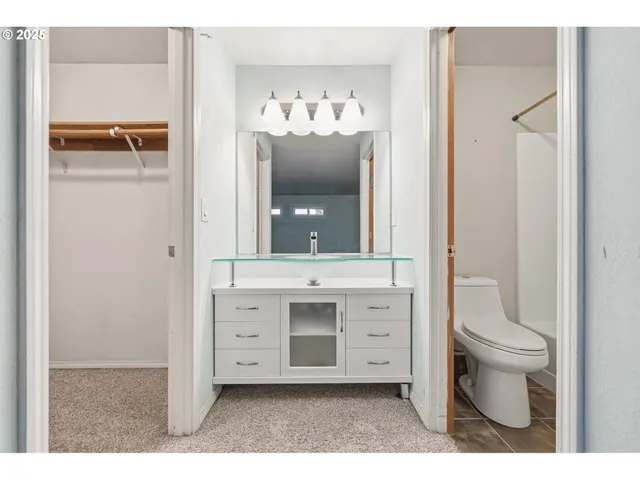 a bathroom with a sink vanity mirror and toilet