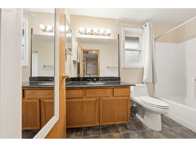 a bathroom with a sink a toilet and a mirror