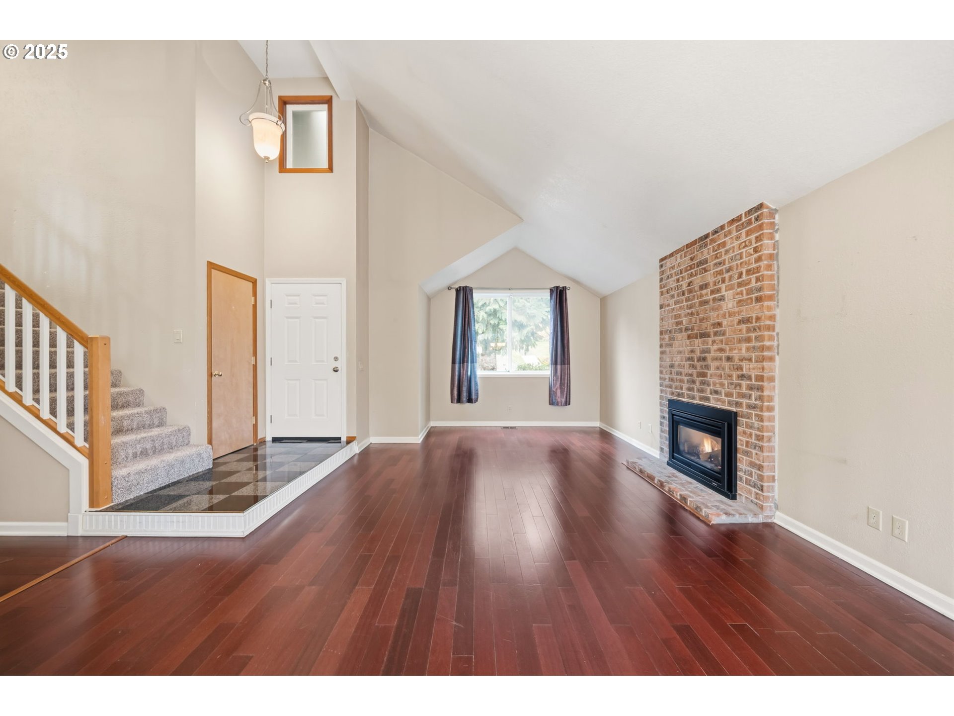 1005 Southwest 4th Street Gresham, OR 97080 - Photo 6 of 40 a view of an empty room with wooden floor fireplace and a window