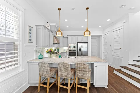 a kitchen with stainless steel appliances granite countertop a sink a stove and white cabinets