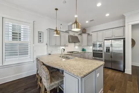 a kitchen with kitchen island a large counter top space appliances and cabinets