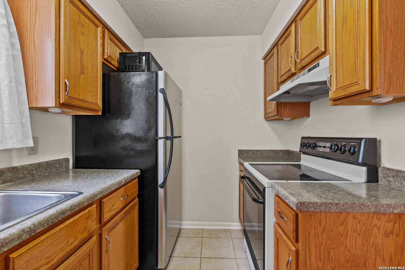 6427 Wurzbach Road, Unit 54 San Antonio, TX 78240 - Photo 4 of 18 a kitchen with stainless steel appliances granite countertop a sink and a refrigerator