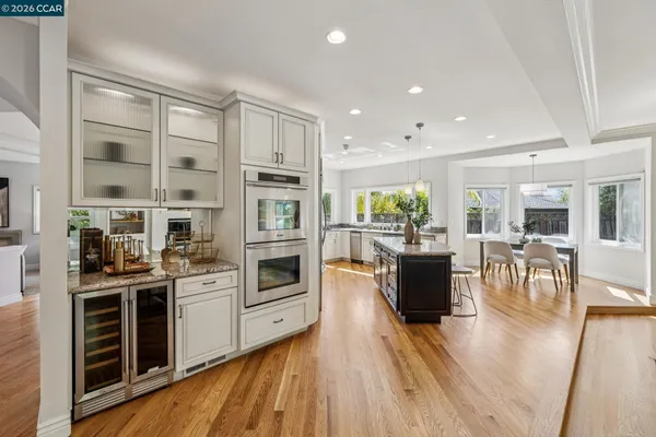 a dining room with furniture potted plants and wooden floor