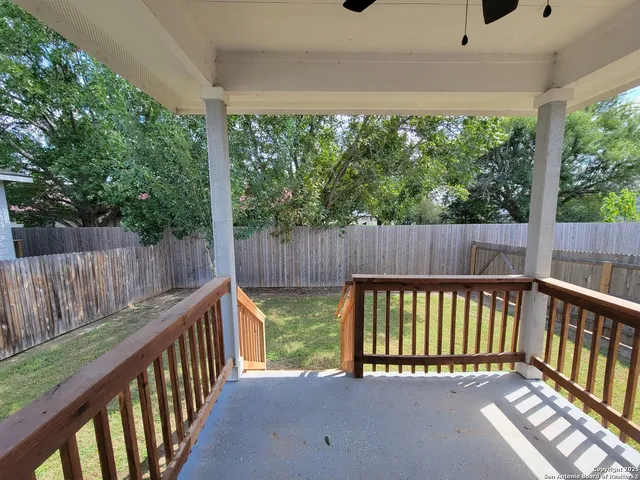 a view of a deck with a floor to ceiling window and wooden fence