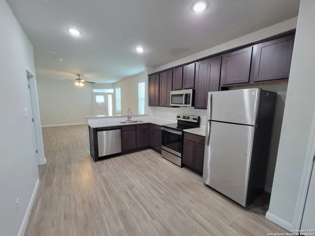 a kitchen with a refrigerator a sink and cabinets