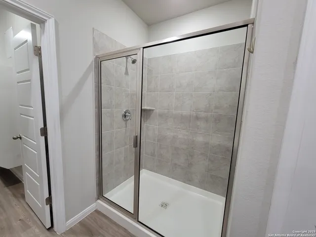 a bathroom with a glass shower door and a window