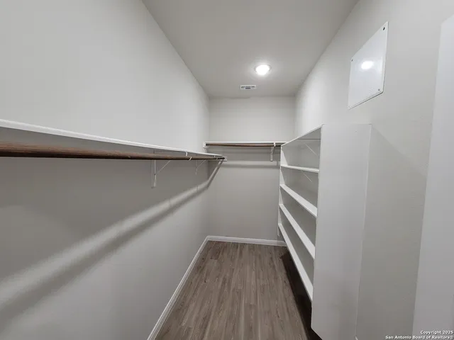 a view of walk in closet with empty racks