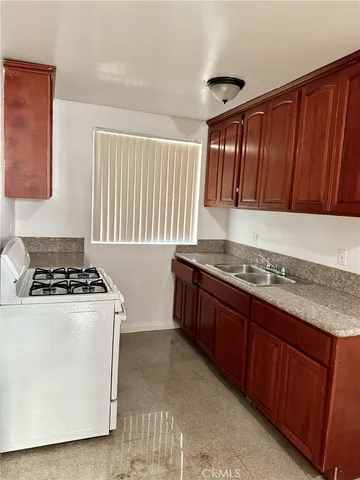 a kitchen with granite countertop a stove and a sink