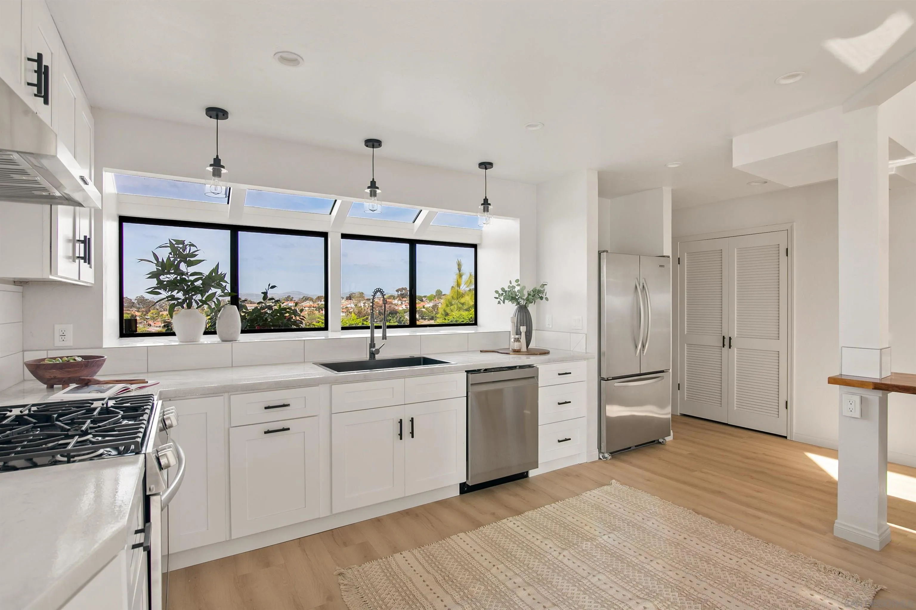 1050 Solana Drive Del Mar, CA 92014 - Photo 16 of 75 a kitchen with white cabinets and stainless steel appliances