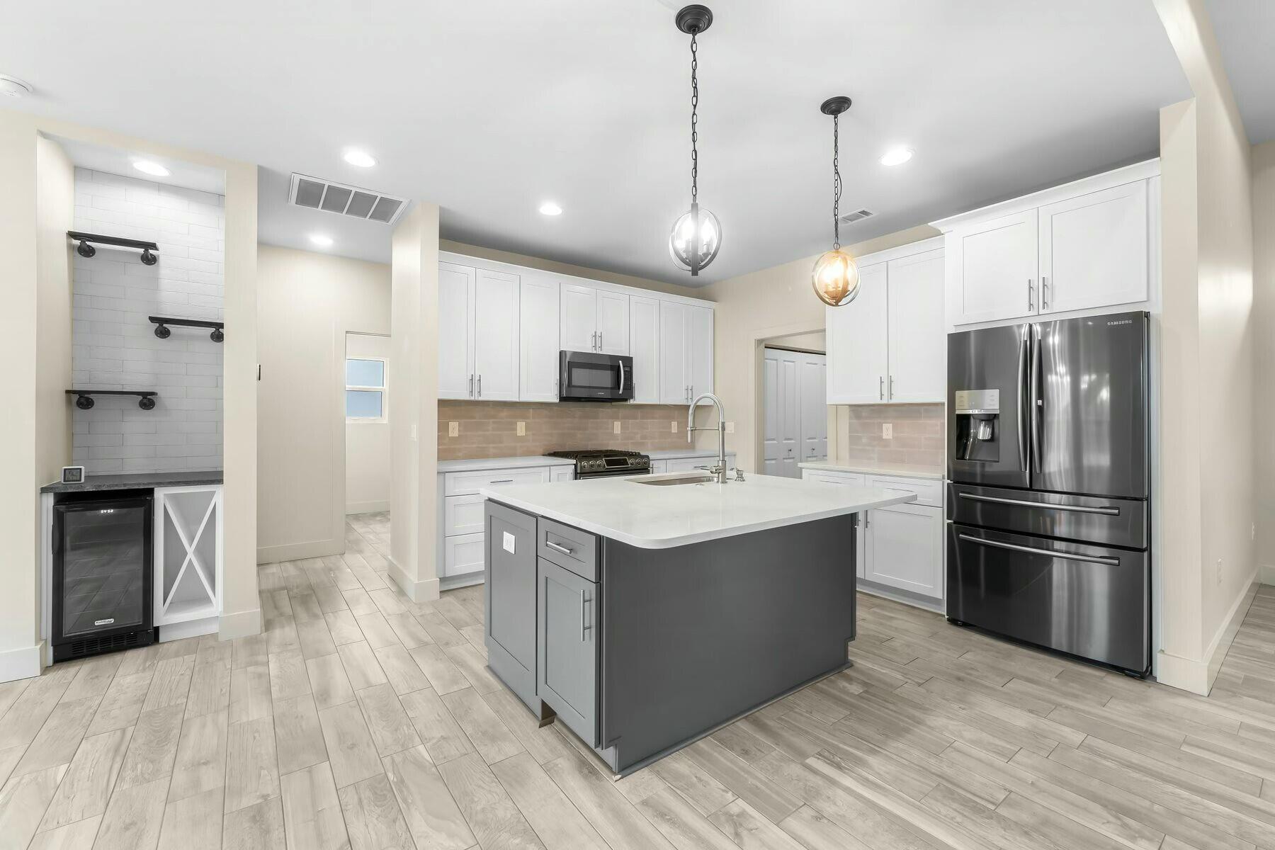 158 Driftwood Point Road Santa Rosa Beach, FL 32459 - Photo 2 of 24 a kitchen with kitchen island a refrigerator stove and wooden floor