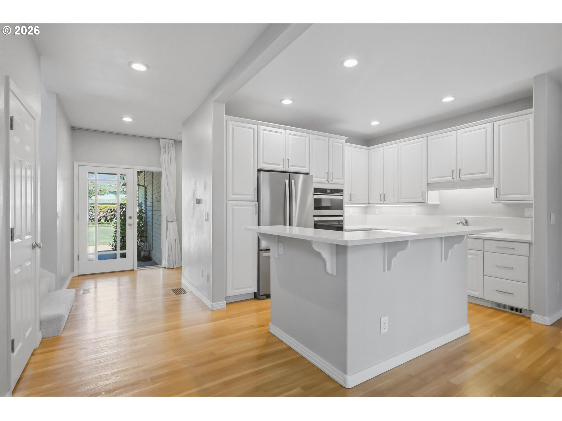 22215 Chelan Loop West Linn, OR 97068 - Photo 5 of 38 a kitchen with stainless steel appliances granite countertop a refrigerator a sink dishwasher a stove and white countertops with wooden floor