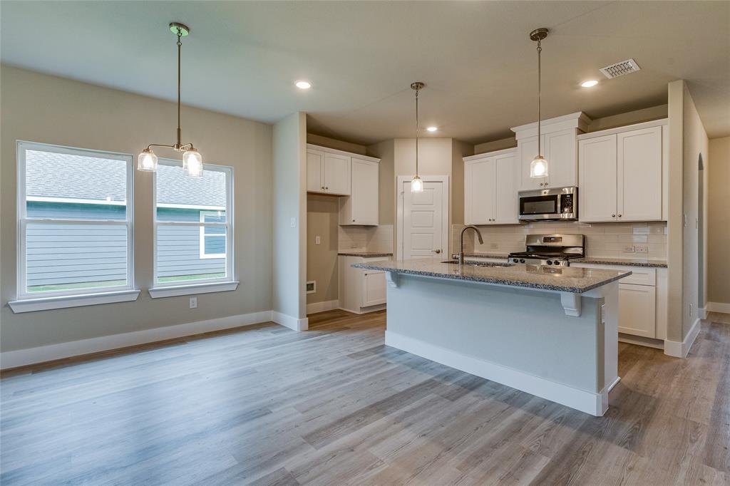 602 Kyle Drive Tioga, TX 76271 - Photo 12 of 29 a kitchen with stainless steel appliances granite countertop a refrigerator a stove and a wooden floors