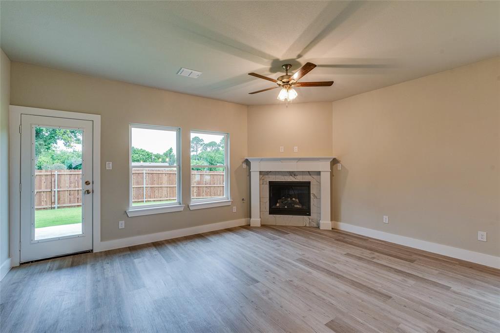 602 Kyle Drive Tioga, TX 76271 - Photo 14 of 29 an empty room with wooden floor fan and windows
