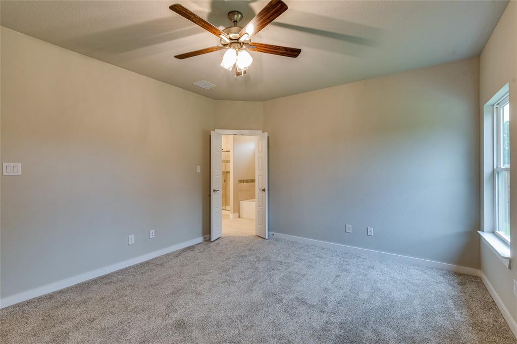 602 Kyle Drive Tioga, TX 76271 - Photo 18 of 29 an empty room with a chandelier fan and windows