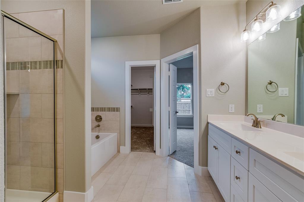602 Kyle Drive Tioga, TX 76271 - Photo 21 of 29 a spacious bathroom with a double vanity sink a mirror and a shower