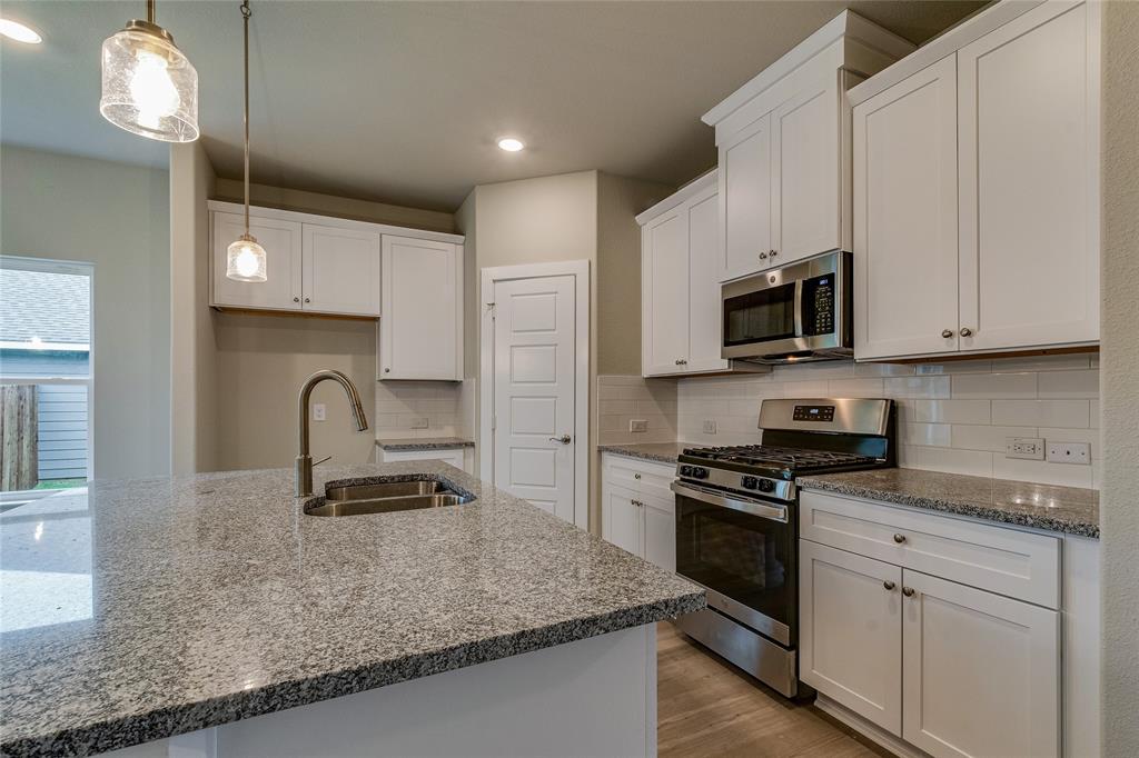 602 Kyle Drive Tioga, TX 76271 - Photo 8 of 29 a kitchen with stainless steel appliances granite countertop a sink a stove top oven a counter space and cabinets