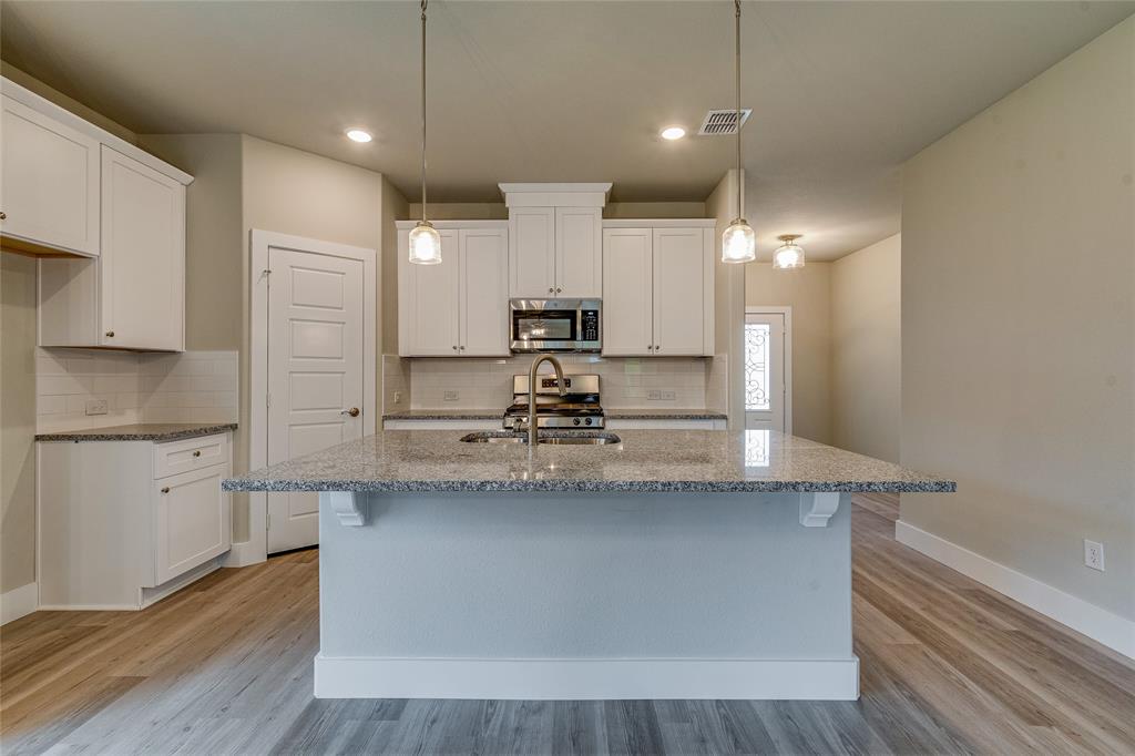 602 Kyle Drive Tioga, TX 76271 - Photo 9 of 29 a kitchen with kitchen island a sink stainless steel appliances and cabinets