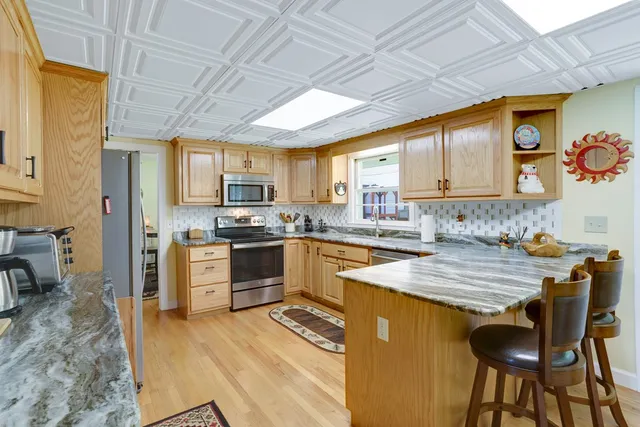 a kitchen with stainless steel appliances granite countertop wooden cabinets a stove top oven a sink and dishwasher