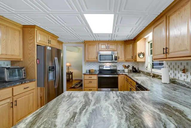 a kitchen with stainless steel appliances granite countertop a refrigerator stove microwave and sink