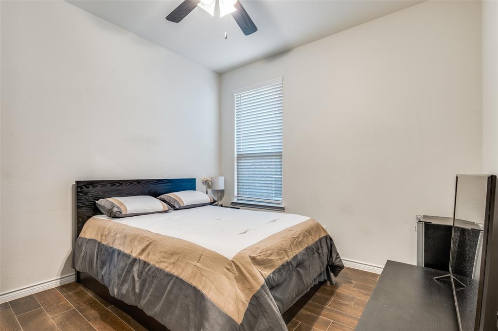 11105 Autry Ridge Lane Aubrey, TX 76227 - Photo 9 of 27 a bedroom with a bed and a flat tv screen on a dresser