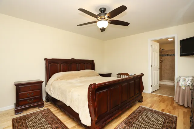 a bedroom with a bed and a ceiling fan
