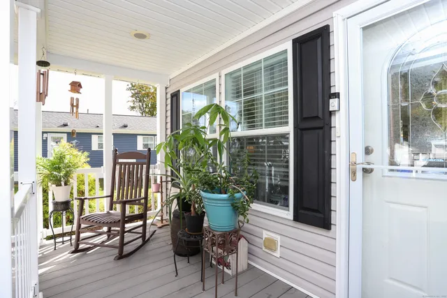 a view of a porch with chairs and potted plants